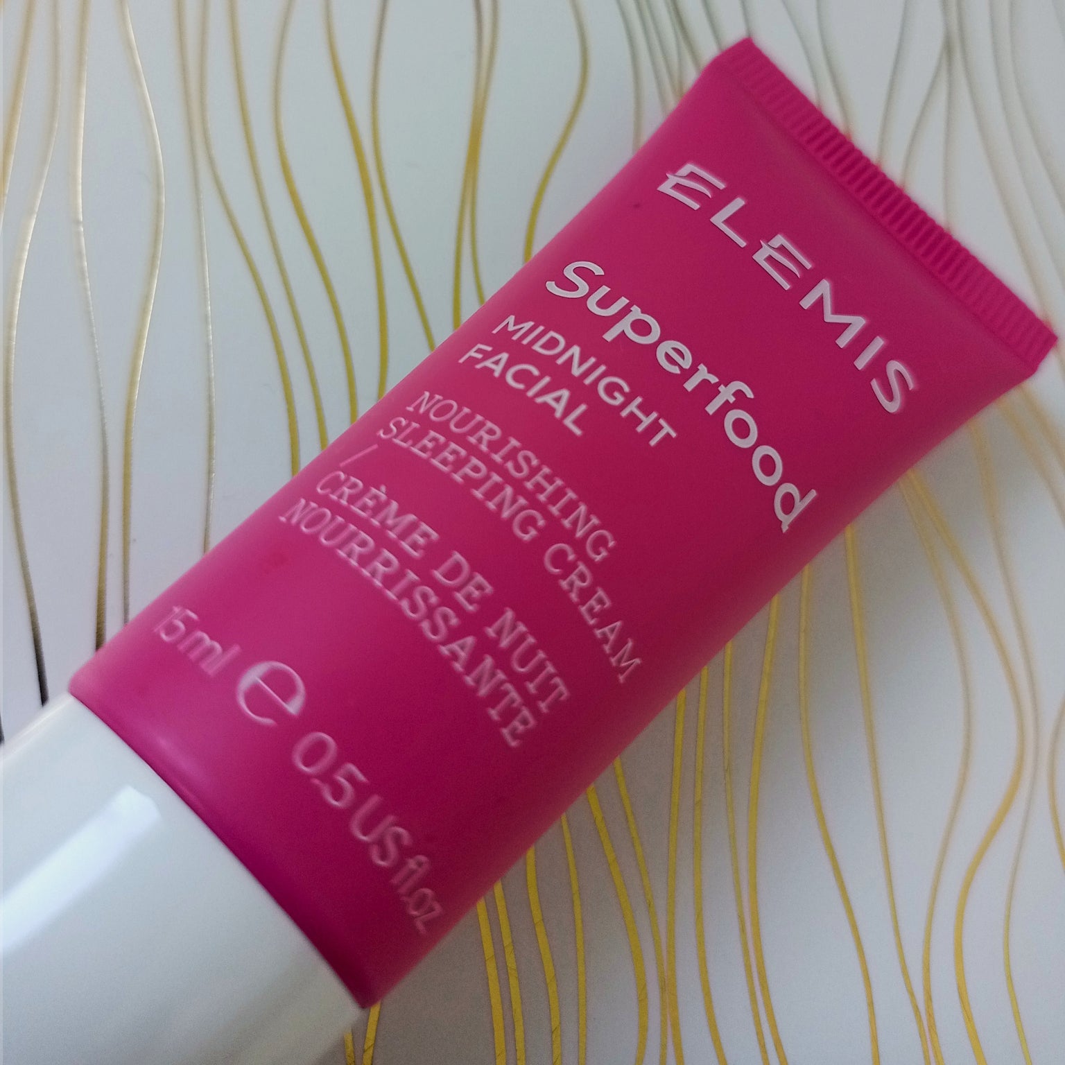 ELEMIS Superfood Midnight Facial Nourishing Sleeping Cream tube on a white background with gold patterns