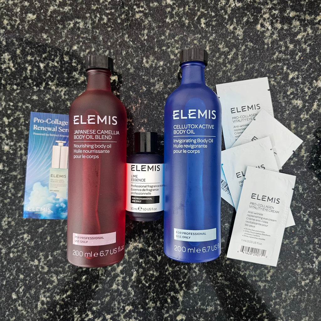 Two Elemis bottles on a textured surface with small packets of Elemis. Available in North Cyprus